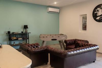 Lit simple avec une tête de lit en bois, couvert d'une couverture à motifs tropicaux, dans une chambre lumineuse.