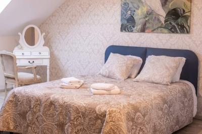 Lit simple avec une tête de lit en bois, couvert d'une couverture à motifs tropicaux, dans une chambre lumineuse.