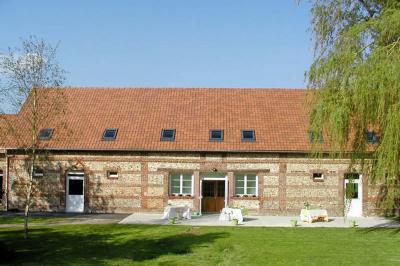 Table extérieure dressée avec des décorations vertes, des verres et des boissons, devant un bâtiment en briques.