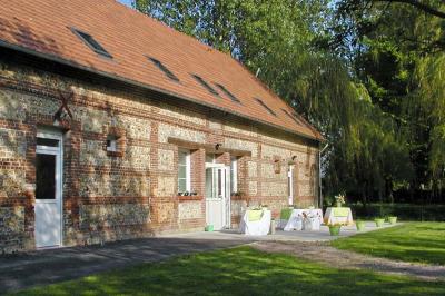 Table extérieure dressée avec des décorations vertes, des verres et des boissons, devant un bâtiment en briques.