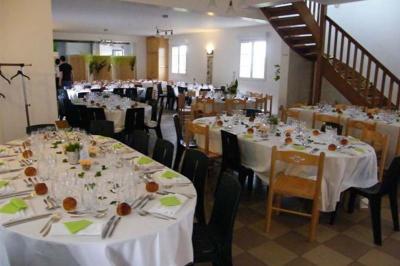 Table extérieure dressée avec des décorations vertes, des verres et des boissons, devant un bâtiment en briques.