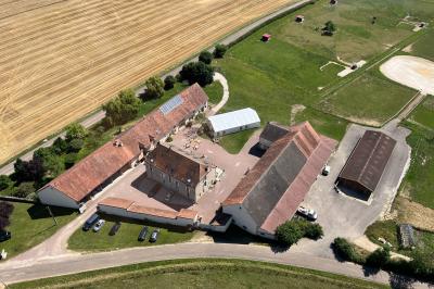 Un homme assis dans un hélicoptère au sol, souriant, avec un coucher de soleil et un champ en arrière-plan.