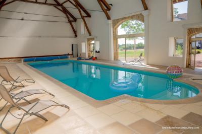 Un homme assis dans un hélicoptère au sol, souriant, avec un coucher de soleil et un champ en arrière-plan.