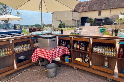 Un homme assis dans un hélicoptère au sol, souriant, avec un coucher de soleil et un champ en arrière-plan.