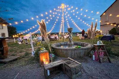 Un homme assis dans un hélicoptère au sol, souriant, avec un coucher de soleil et un champ en arrière-plan.