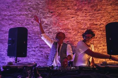 Un homme assis dans un hélicoptère au sol, souriant, avec un coucher de soleil et un champ en arrière-plan.