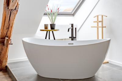 Un homme assis dans un hélicoptère au sol, souriant, avec un coucher de soleil et un champ en arrière-plan.