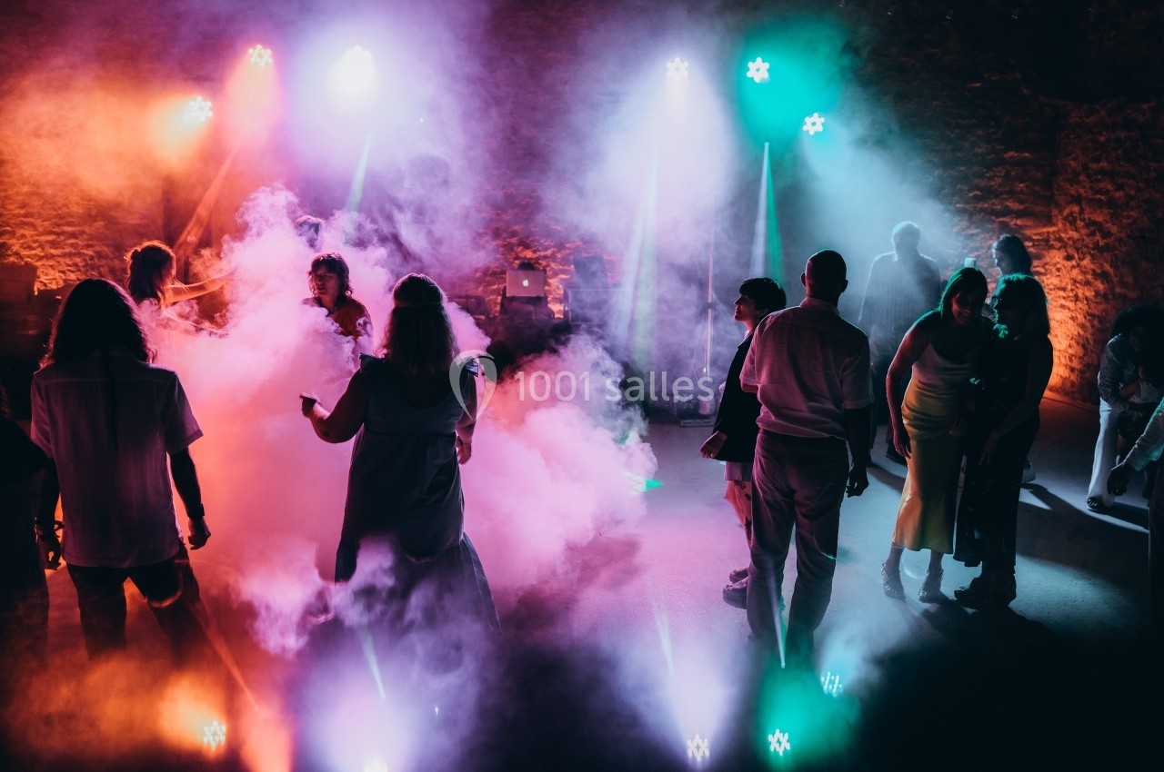 Location salle Souhey (Côte-d'Or) - La Maison de Souhey #91 Personnes dansant dans une ambiance festive avec éclairages colorés et fumée sur une piste de danse.