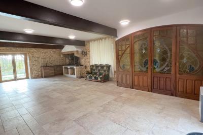 Chambre lumineuse avec lit double, coin salon, salle de bain ouverte avec douche à l'italienne et lavabo moderne.