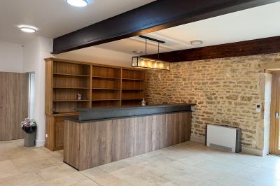 Chambre lumineuse avec lit double, coin salon, salle de bain ouverte avec douche à l'italienne et lavabo moderne.