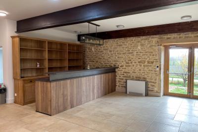 Chambre lumineuse avec lit double, coin salon, salle de bain ouverte avec douche à l'italienne et lavabo moderne.