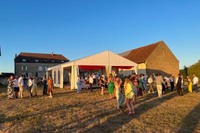 Chambre lumineuse avec lit double, coin salon, salle de bain ouverte avec douche à l'italienne et lavabo moderne.