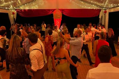 Chambre lumineuse avec lit double, coin salon, salle de bain ouverte avec douche à l'italienne et lavabo moderne.