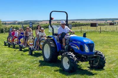Chambre lumineuse avec lit double, coin salon, salle de bain ouverte avec douche à l'italienne et lavabo moderne.