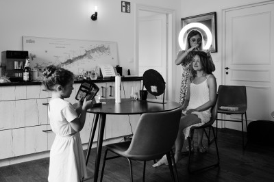 Des invités assis à des tables dans une tente décorée, profitant d'un repas avec vue sur un paysage champêtre au coucher du…