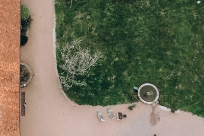 Des invités assis à des tables dans une tente décorée, profitant d'un repas avec vue sur un paysage champêtre au coucher du…