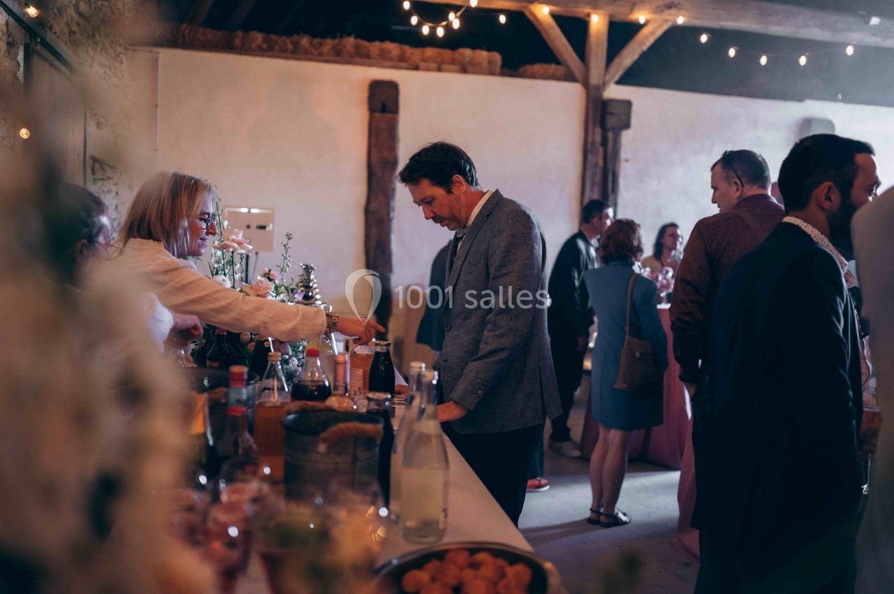 Des invités se servent à un buffet dans une salle décorée avec des guirlandes lumineuses.