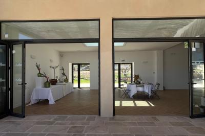 Bouteille de vin rosé entourée de verres vides sur une table en bois, avec une plante en arrière-plan.