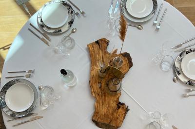 Bouteille de vin rosé entourée de verres vides sur une table en bois, avec une plante en arrière-plan.