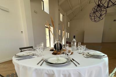 Bouteille de vin rosé entourée de verres vides sur une table en bois, avec une plante en arrière-plan.