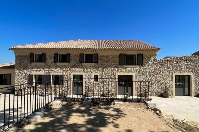 Bouteille de vin rosé entourée de verres vides sur une table en bois, avec une plante en arrière-plan.