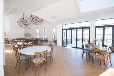 Bouteille de vin rosé entourée de verres vides sur une table en bois, avec une plante en arrière-plan.