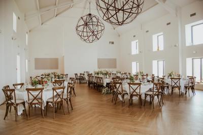 Bouteille de vin rosé entourée de verres vides sur une table en bois, avec une plante en arrière-plan.