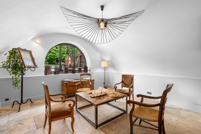 Main d'une personne tenant légèrement une robe blanche, avec un bracelet fin et une bague visible.