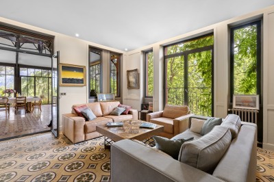 Main d'une personne tenant légèrement une robe blanche, avec un bracelet fin et une bague visible.