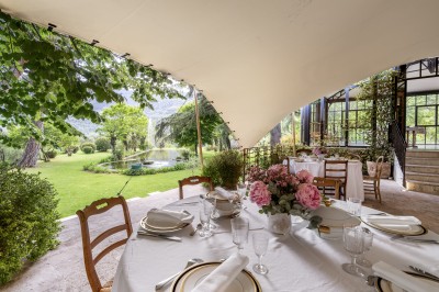 Main d'une personne tenant légèrement une robe blanche, avec un bracelet fin et une bague visible.