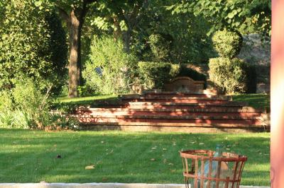 Main d'une personne tenant légèrement une robe blanche, avec un bracelet fin et une bague visible.