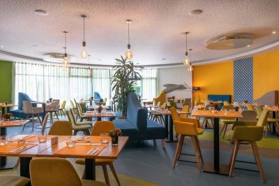 Salle de soins avec table de massage, serviette, produits de beauté, bougies allumées et plantes décoratives.