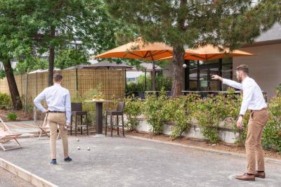 Salle de soins avec table de massage, serviette, produits de beauté, bougies allumées et plantes décoratives.