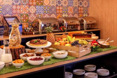 Salle de soins avec table de massage, serviette, produits de beauté, bougies allumées et plantes décoratives.