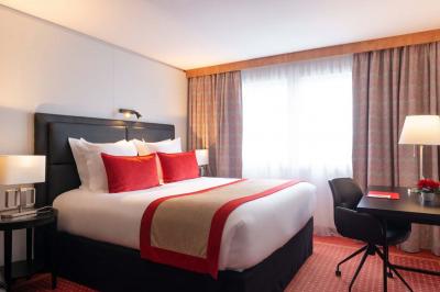 Salle de soins avec table de massage, serviette, produits de beauté, bougies allumées et plantes décoratives.