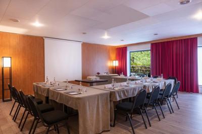 Salle de soins avec table de massage, serviette, produits de beauté, bougies allumées et plantes décoratives.