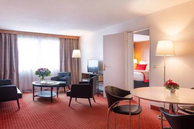 Salle de soins avec table de massage, serviette, produits de beauté, bougies allumées et plantes décoratives.