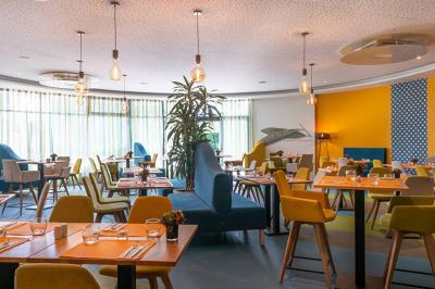 Salle de soins avec table de massage, serviette, produits de beauté, bougies allumées et plantes décoratives.