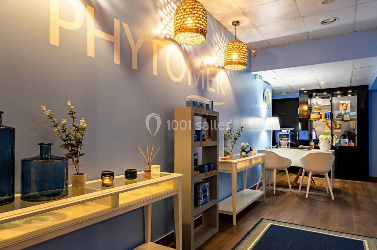 Intérieur d'un espace bien-être avec étagères, produits de soin, éclairage chaleureux et mobilier moderne.