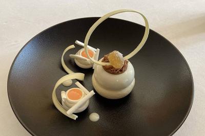 Salle de soins avec table de massage, serviette, produits de beauté, bougies allumées et plantes décoratives.