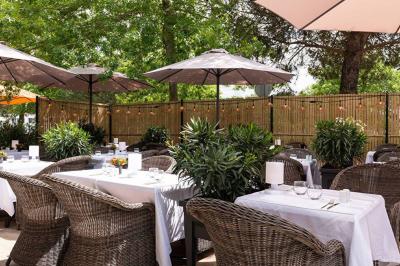Salle de soins avec table de massage, serviette, produits de beauté, bougies allumées et plantes décoratives.