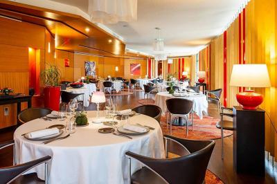 Salle de soins avec table de massage, serviette, produits de beauté, bougies allumées et plantes décoratives.