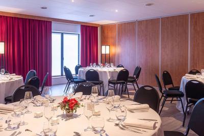 Salle de soins avec table de massage, serviette, produits de beauté, bougies allumées et plantes décoratives.