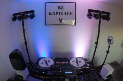 Un DJ mixe en plein air devant une foule, avec l'Arche de la Défense en arrière-plan.