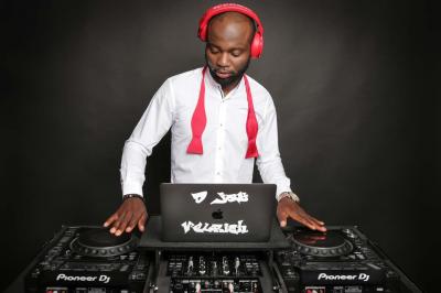 Un DJ mixe en plein air devant une foule, avec l'Arche de la Défense en arrière-plan.