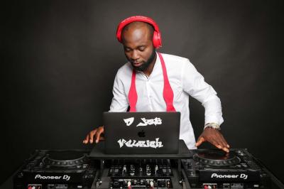 Un DJ mixe en plein air devant une foule, avec l'Arche de la Défense en arrière-plan.