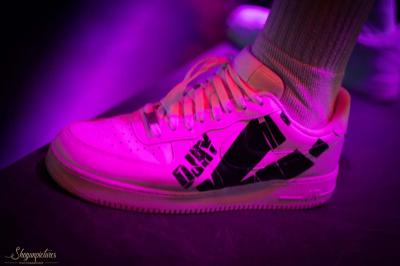 Un DJ mixe en plein air devant une foule, avec l'Arche de la Défense en arrière-plan.