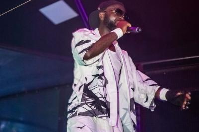 Un DJ mixe en plein air devant une foule, avec l'Arche de la Défense en arrière-plan.