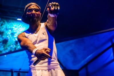 Un DJ mixe en plein air devant une foule, avec l'Arche de la Défense en arrière-plan.