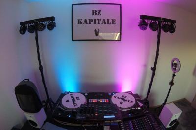 Un DJ mixe en plein air devant une foule, avec l'Arche de la Défense en arrière-plan.